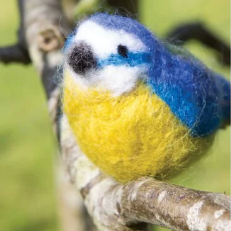 Felted bird toy with blue and yellow colors on a branch