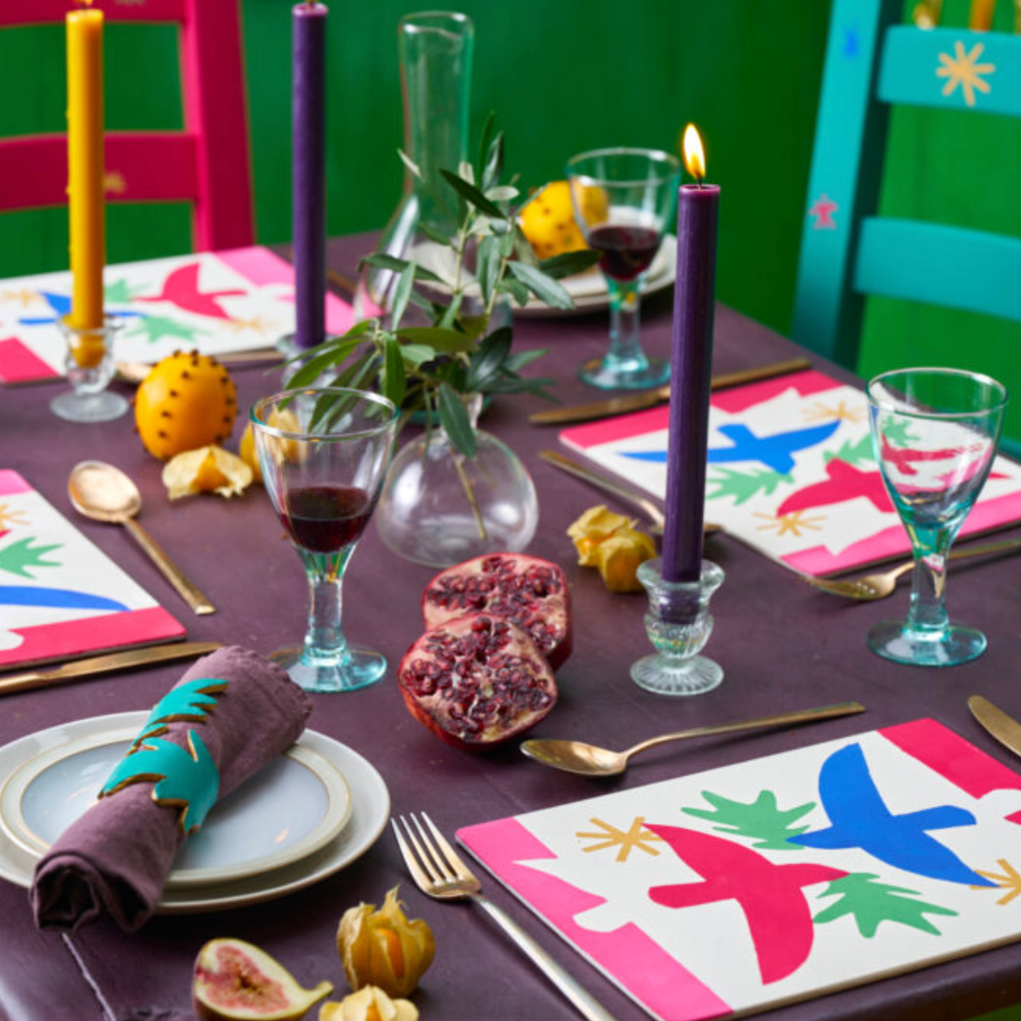 A screenshot of a website displaying a Christmas table setting inspiration photo with colorful placemats, candles, and festive tableware, shown within a web browser interface.