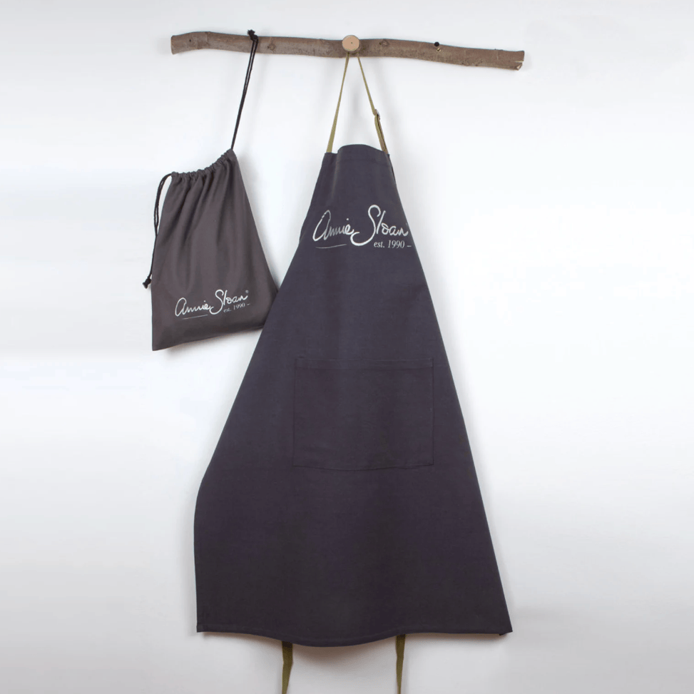 A screenshot of an e-commerce product page for an Arisoe Blue Apron, showing the apron hanging on a wooden dowel. The page includes product images, pricing, customer reviews, and product details on a white background.