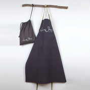 A screenshot of an e-commerce product page for an Arisoe Blue Apron, showing the apron hanging on a wooden dowel. The page includes product images, pricing, customer reviews, and product details on a white background.