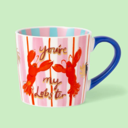 A ceramic mug with a pink and white striped design, featuring red lobster illustrations and the phrase 'you're my Lobster' in gold script. The mug has a blue handle and a blue interior, set against a solid light green background.
