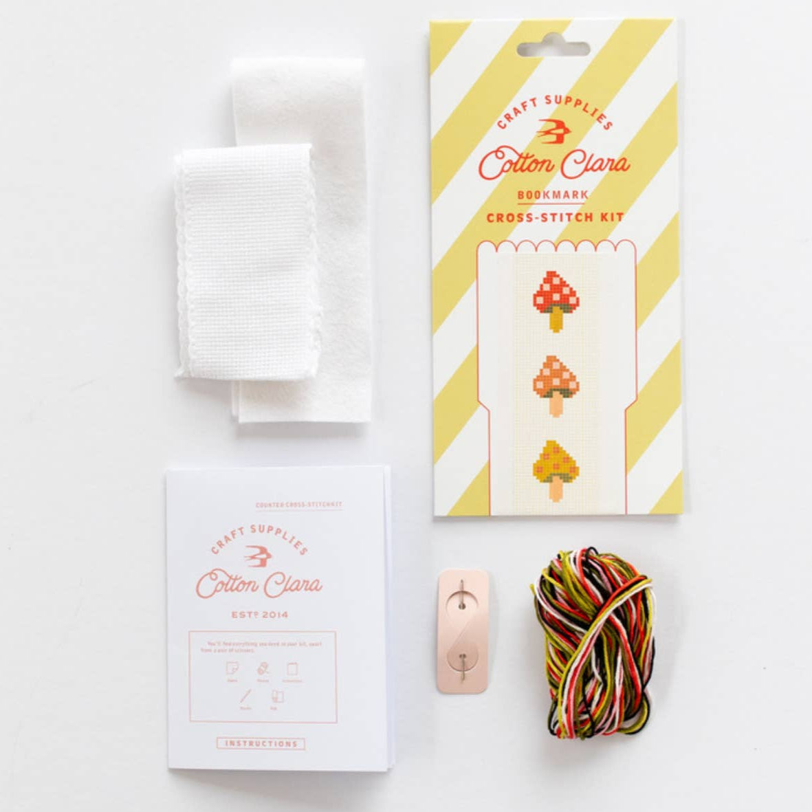 Cross-stitch kit with materials on a white background