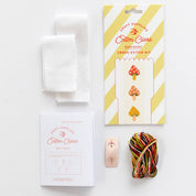 Cross-stitch kit with materials on a white background