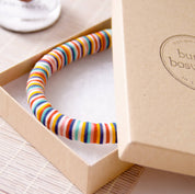 Colorful striped bracelet in a box on a light surface