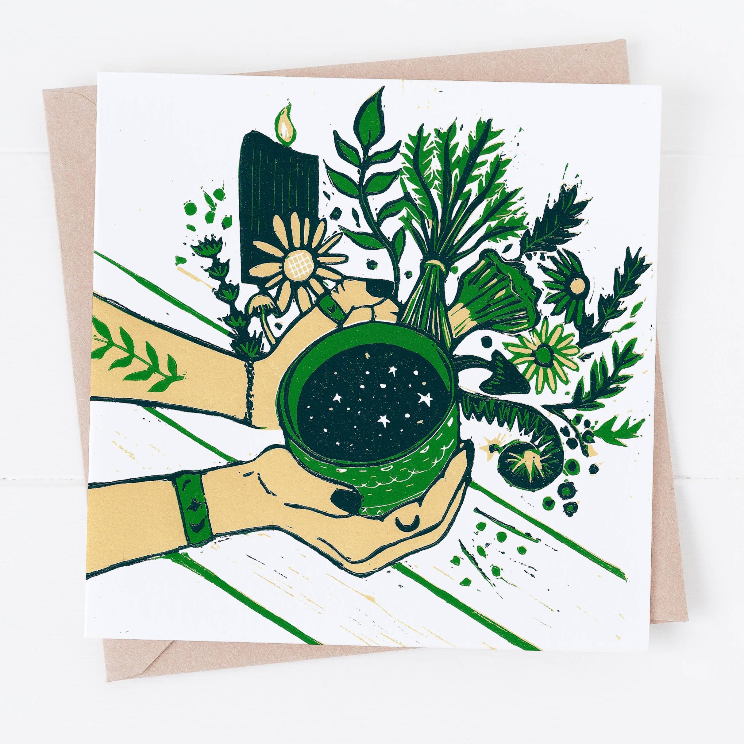 Greeting card with hands holding a green cup surrounded by plants and nature elements.