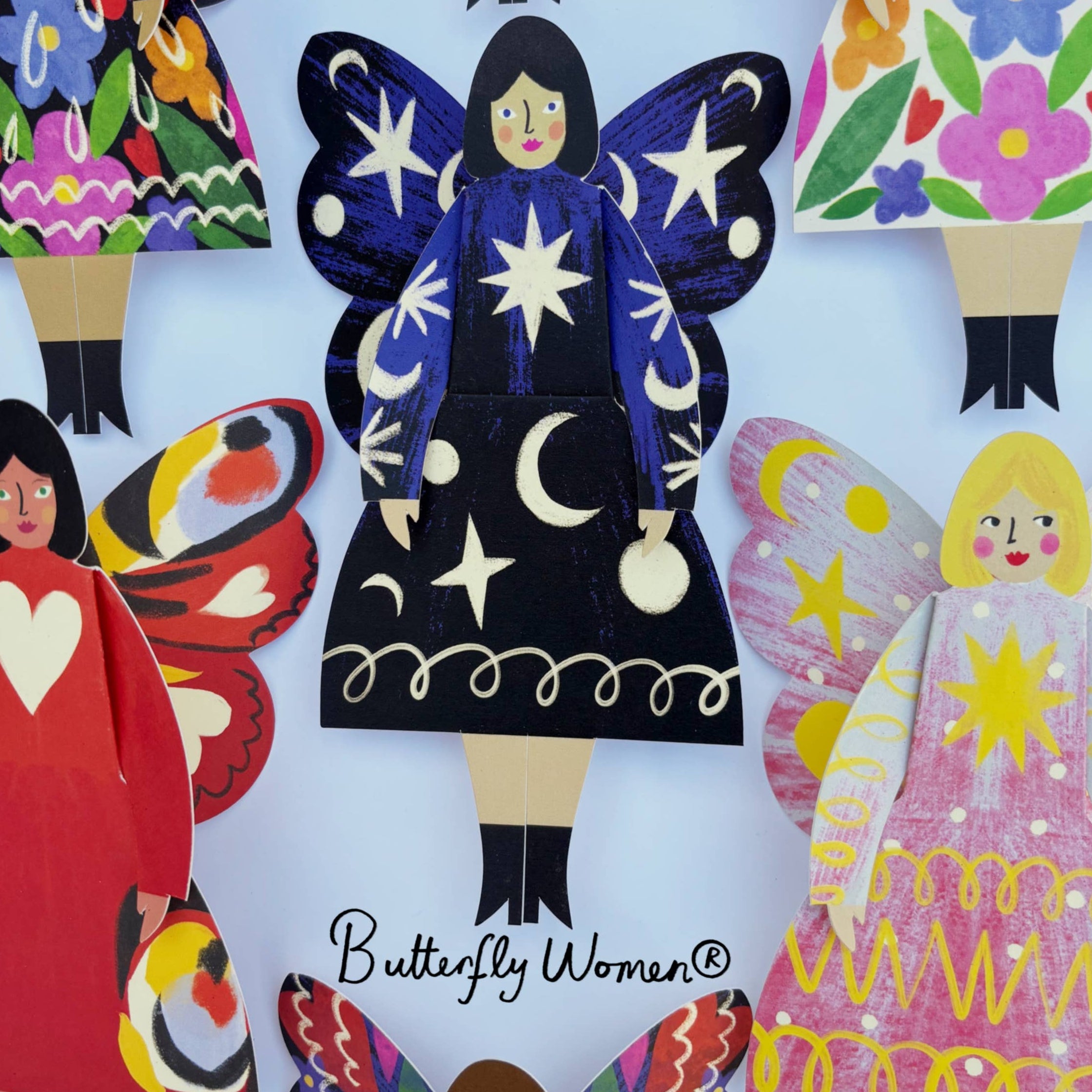 Colorful paper dolls with butterfly wings and colorful dresses, featuring the brand 'Kitty Kenda'.