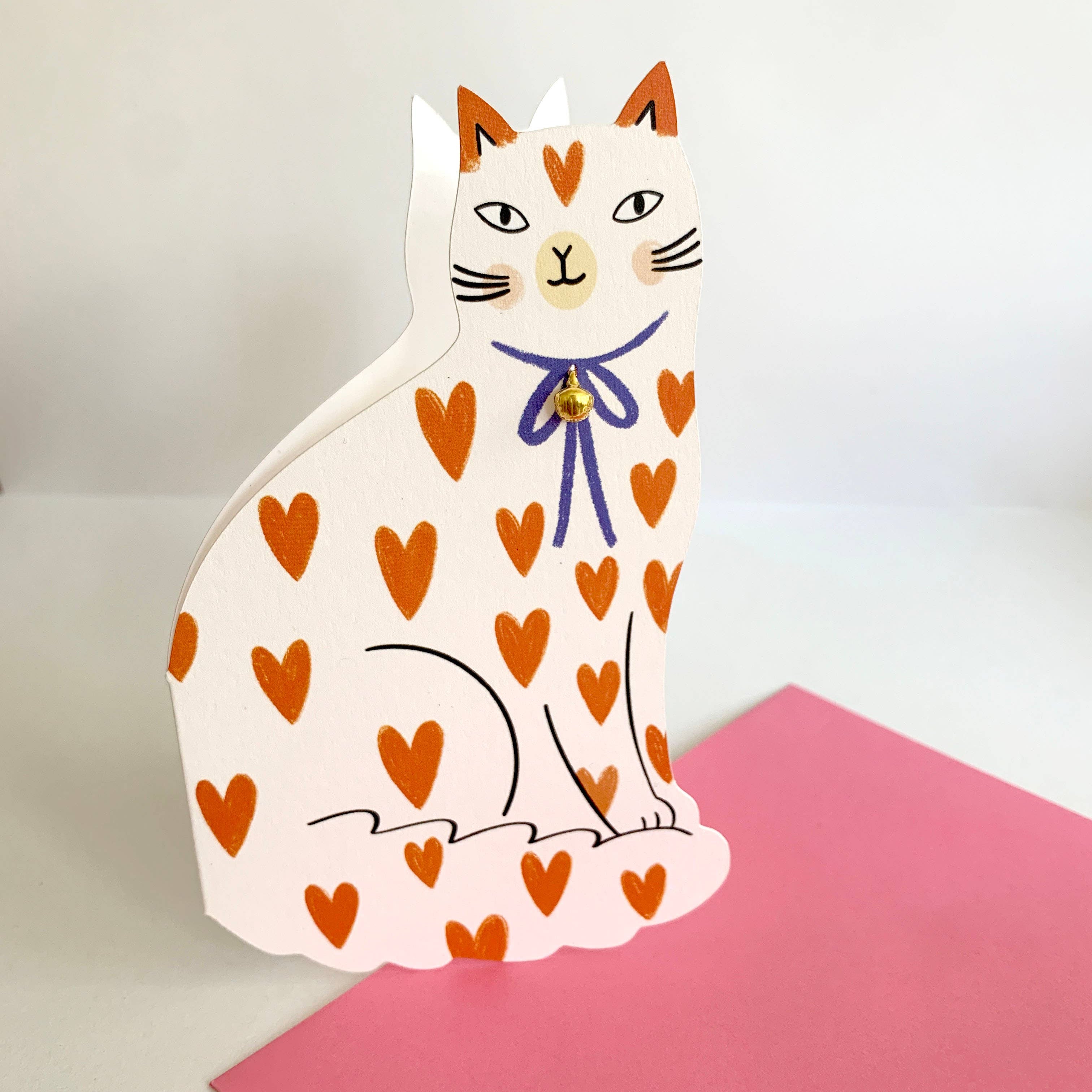 Card with a cat design featuring orange hearts on a pink card