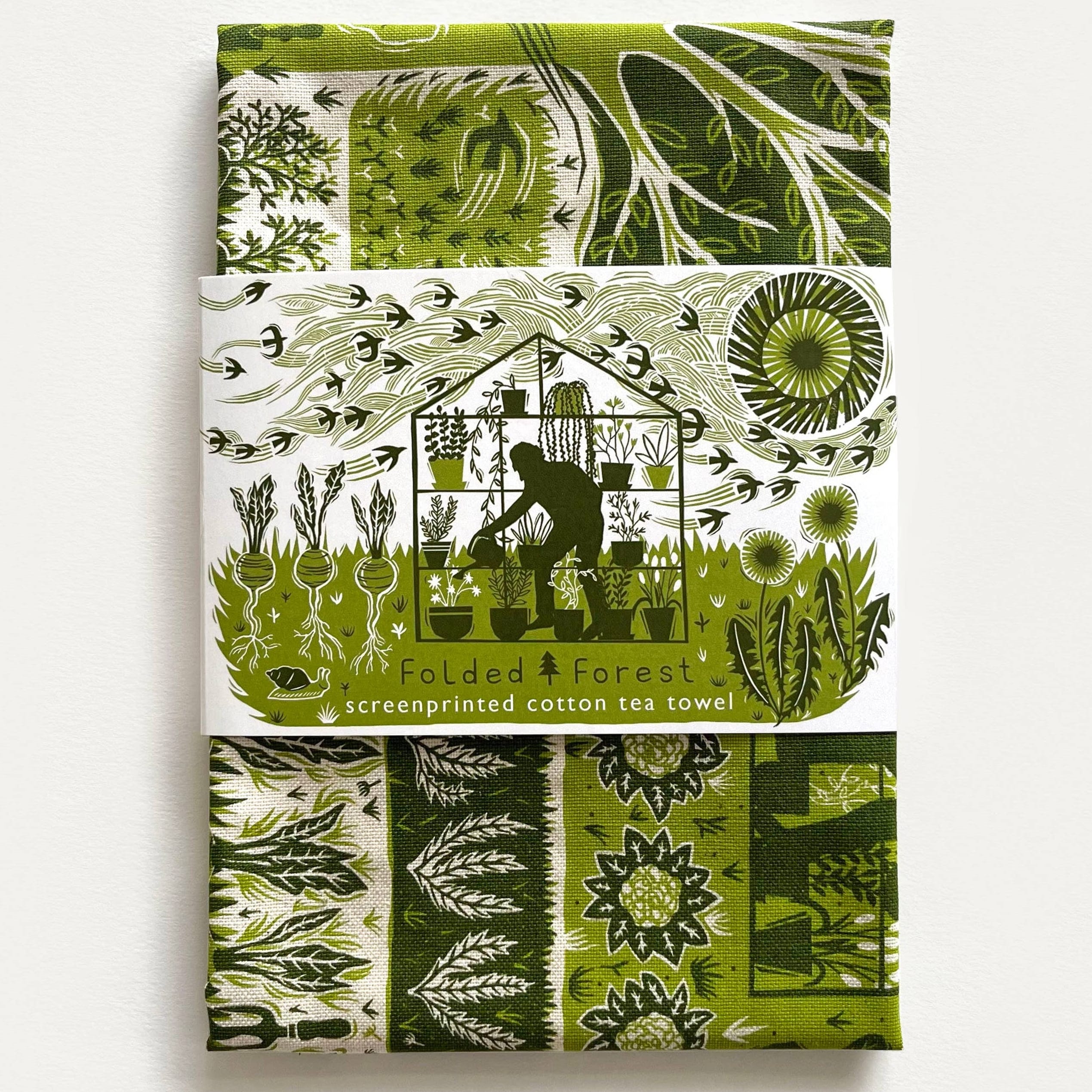 Green and white patterned tea towel with screenprinted design on a white background