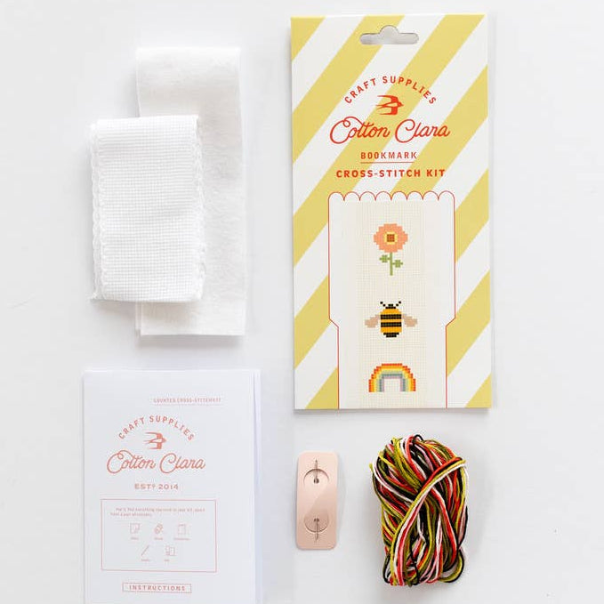 Cotton Clara embroidery cross-stitch kit with packaging, thread, and needle on a white background