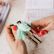 Person cutting yarn with scissors on a polka dot fabric background