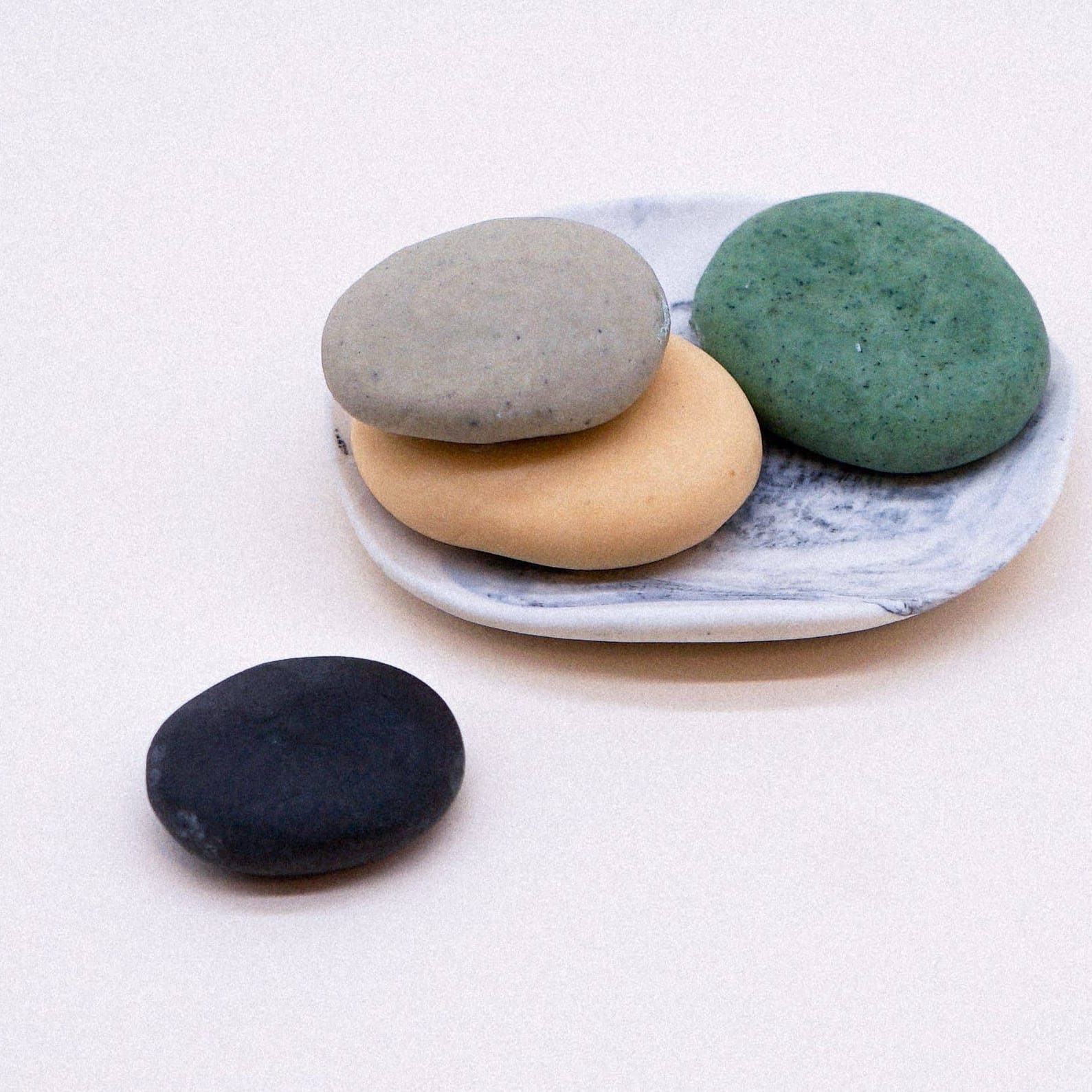 Set of colorful stones on a marble plate with a white background