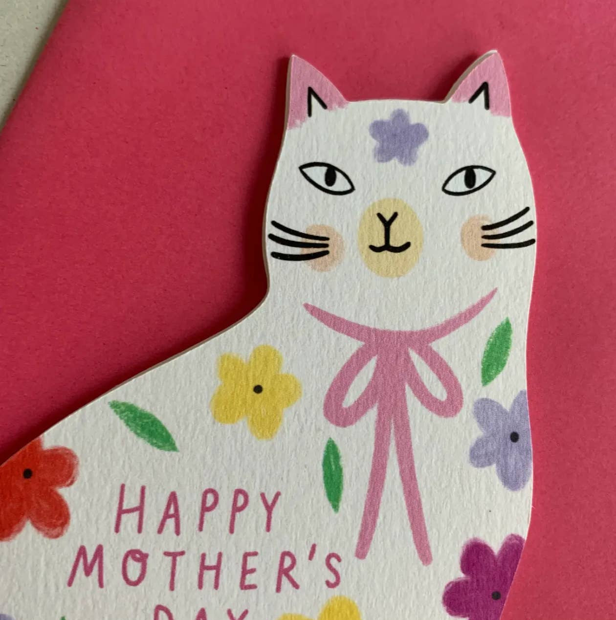 Cat-shaped card with 'Happy Mother's Day' text and floral decorations on a pink background