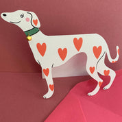 Cardboard dog with heart patterns on a red background