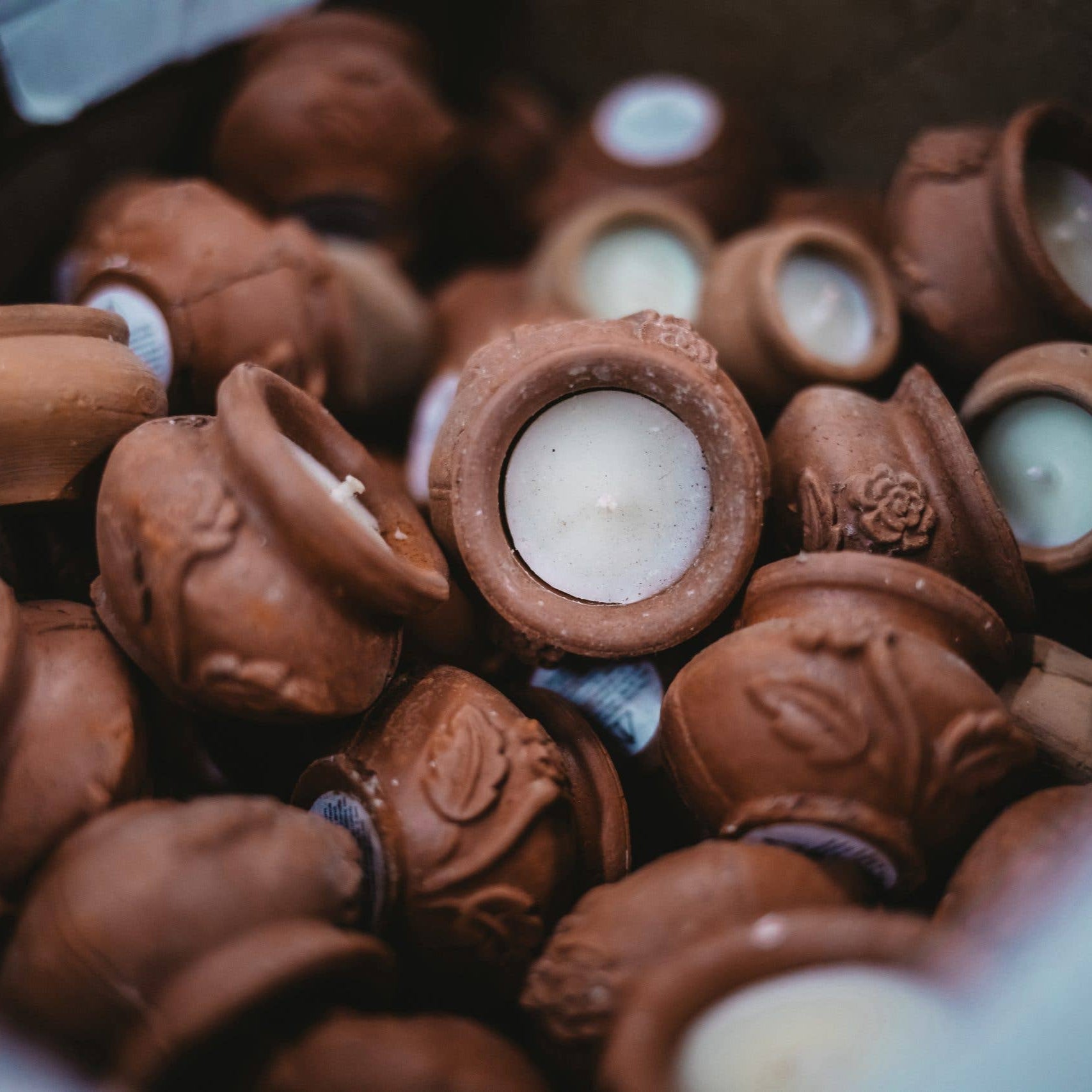 Close-up of small chocolate containers with candles inside