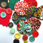 Colorful fabric flowers and buttons on a white background