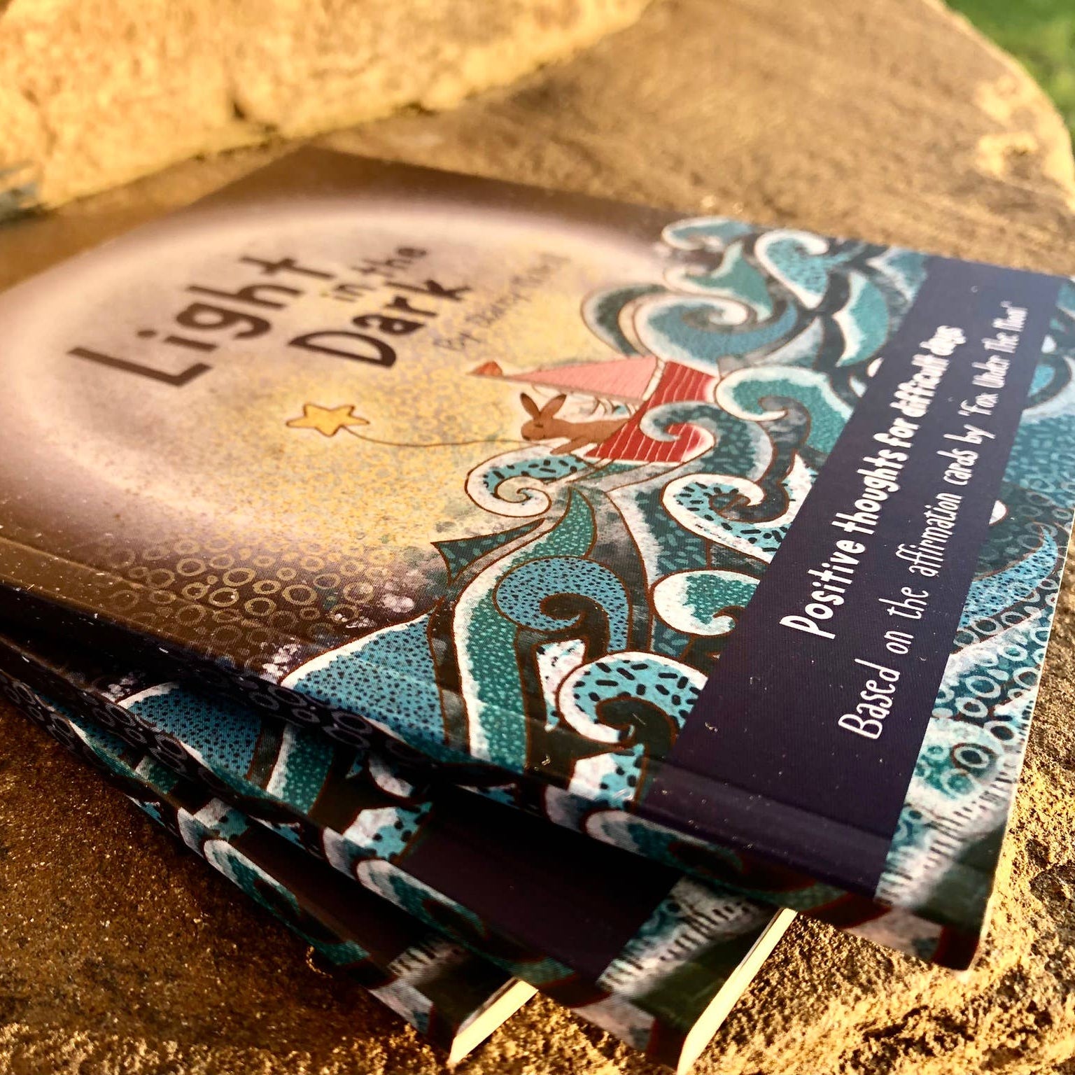 Card deck titled 'Light & Dark' with decorative cover on a textured surface