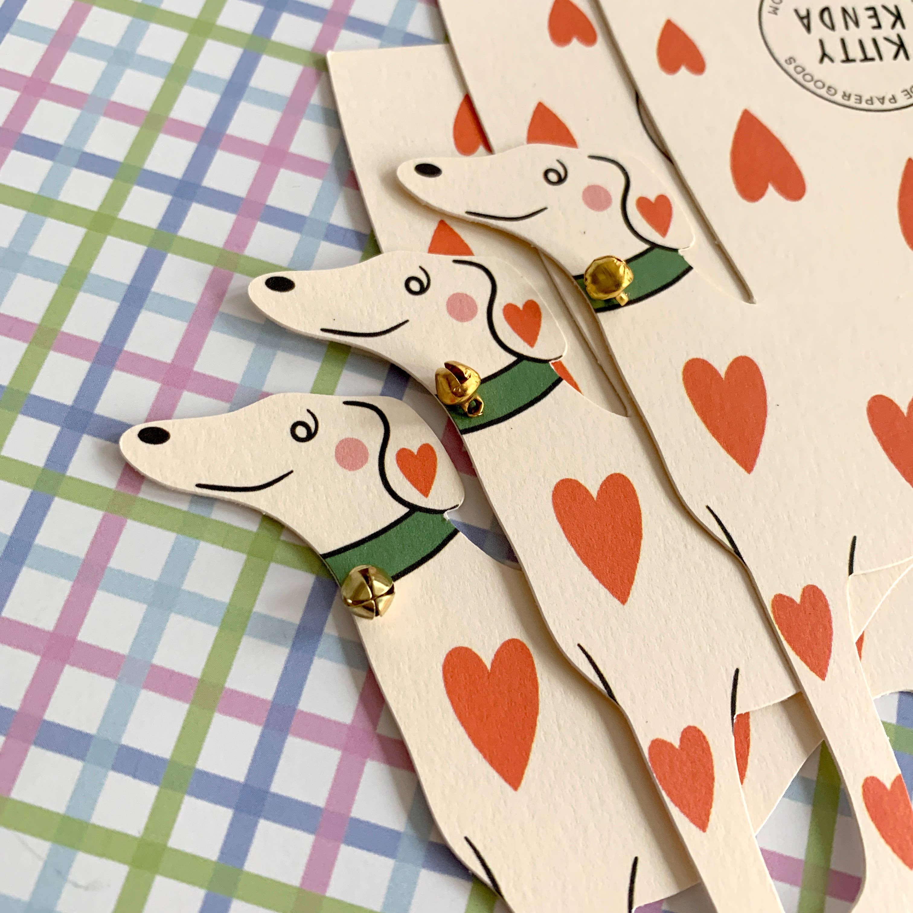 Wooden dog-shaped bookmarks with heart patterns on a colorful checkered background