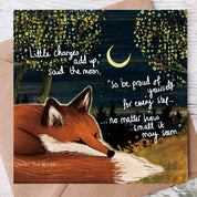Greeting card with a fox illustration and motivational quote on a wooden surface.