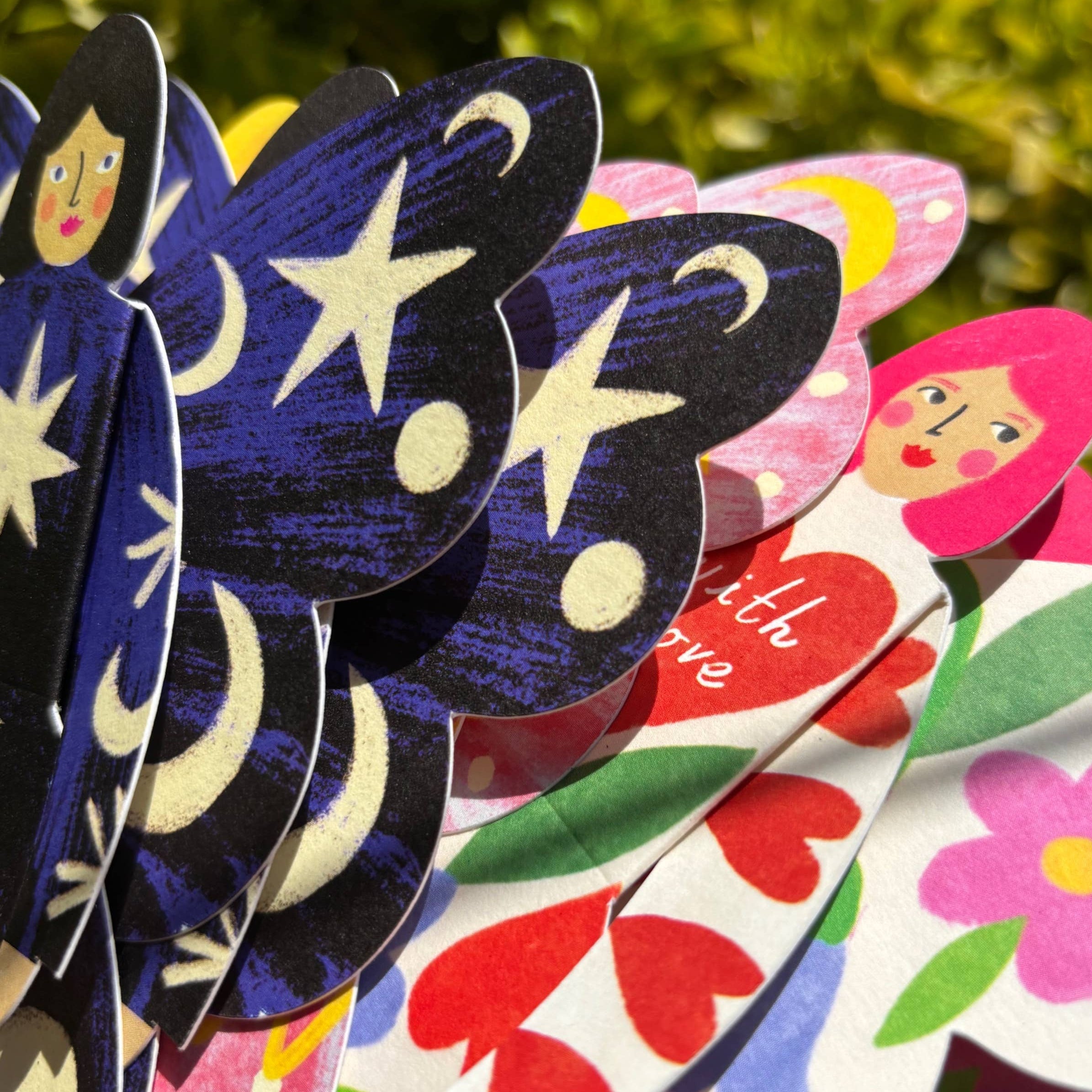 Colorful butterfly-shaped paper dolls with floral and heart designs, branded 'Butterfly Women by Kitty Kenda'.