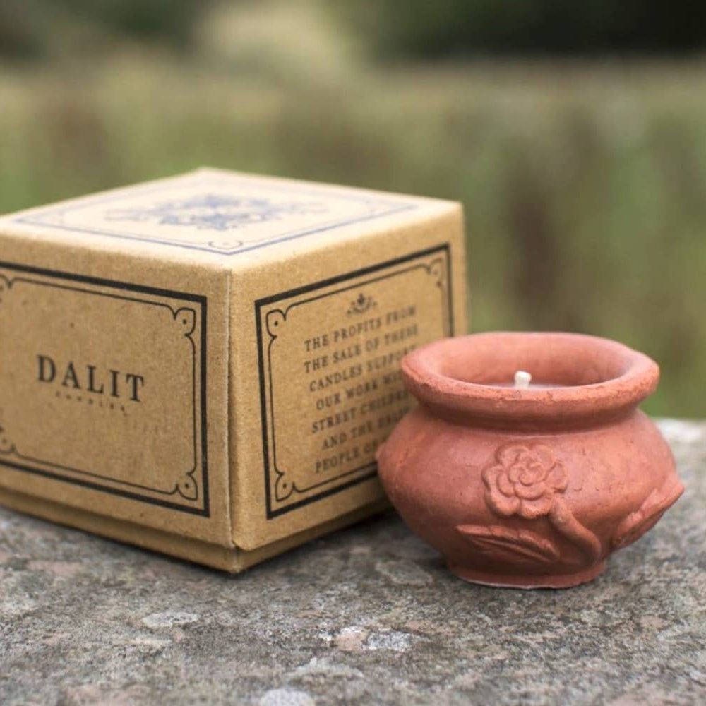 Terracotta candle holder with 'DALIT' branding on a stone surface