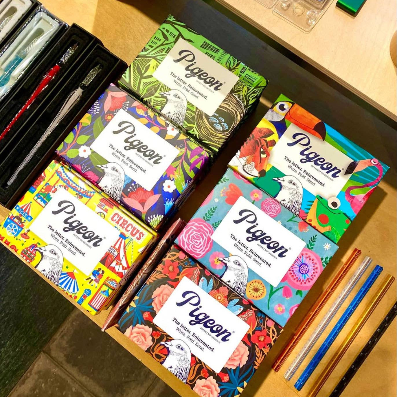 Colorful art supplies including sketchbooks and markers on a wooden surface.