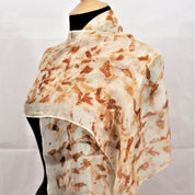 Beige and brown patterned scarf on a mannequin against a white background